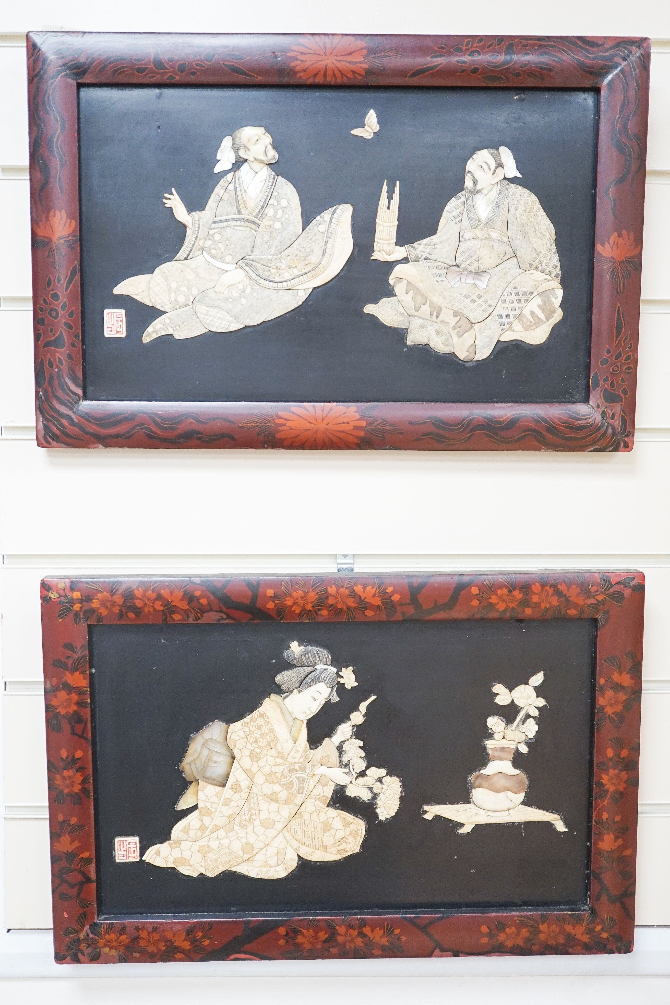 A pair of Japanese Shibayama style ivory, bone and mother of pearl inlaid lacquer panels, Meiji period, depicting two seated men, the other a bijin, 30 x 45cm